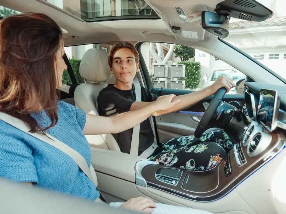 Parent and teen sitting together in a car during a driving lesson